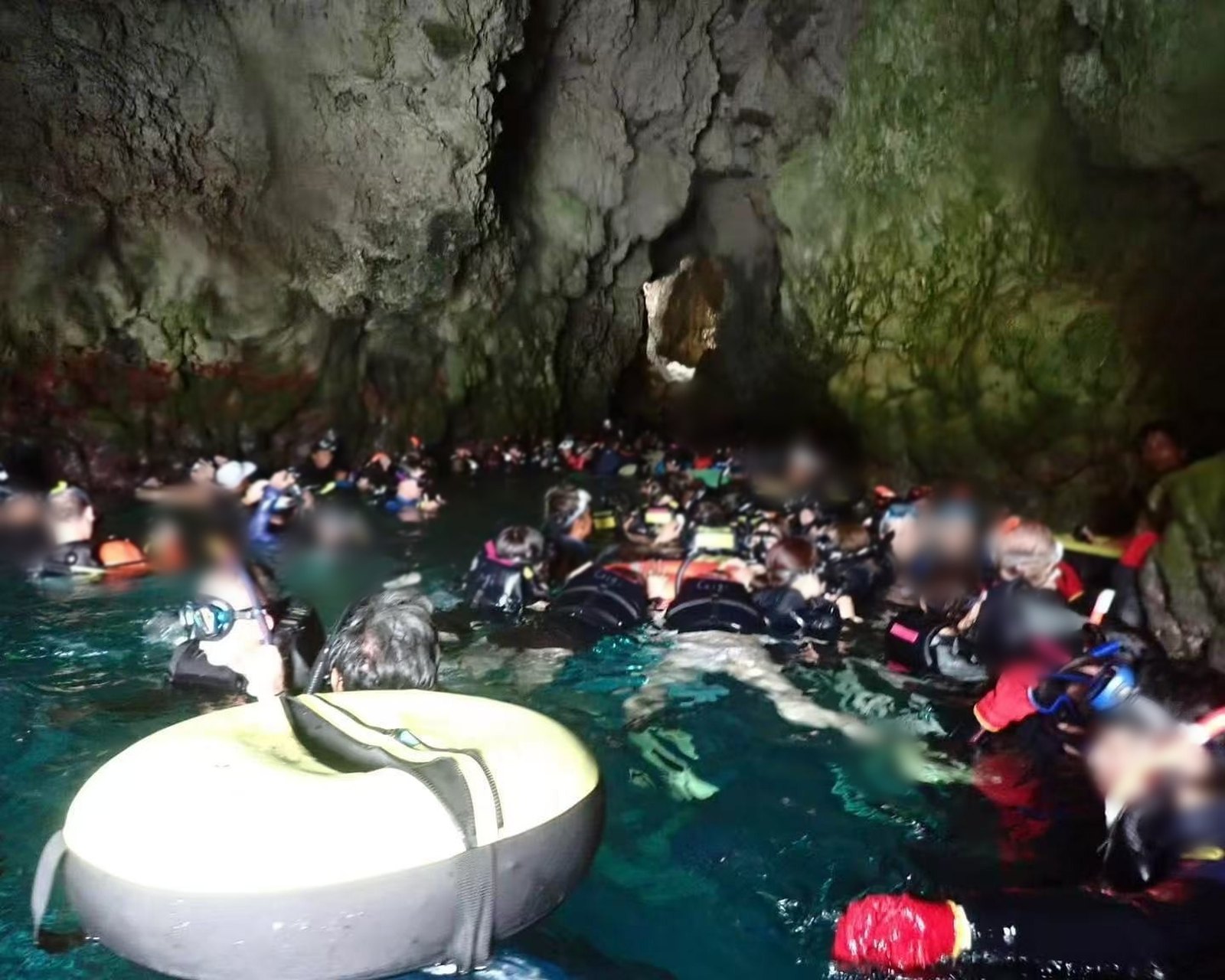 Snorkelers packed shoulder to shoulder inside the Blue Cave, Okinawa, during July, August and September